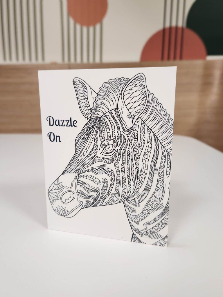 A color book with a zebra and text: Dazzle On