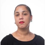 A black woman with red lipstick and a black shirt.